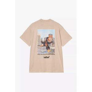 Beige t-shirt with a graphic design of a character holding a building on a white background