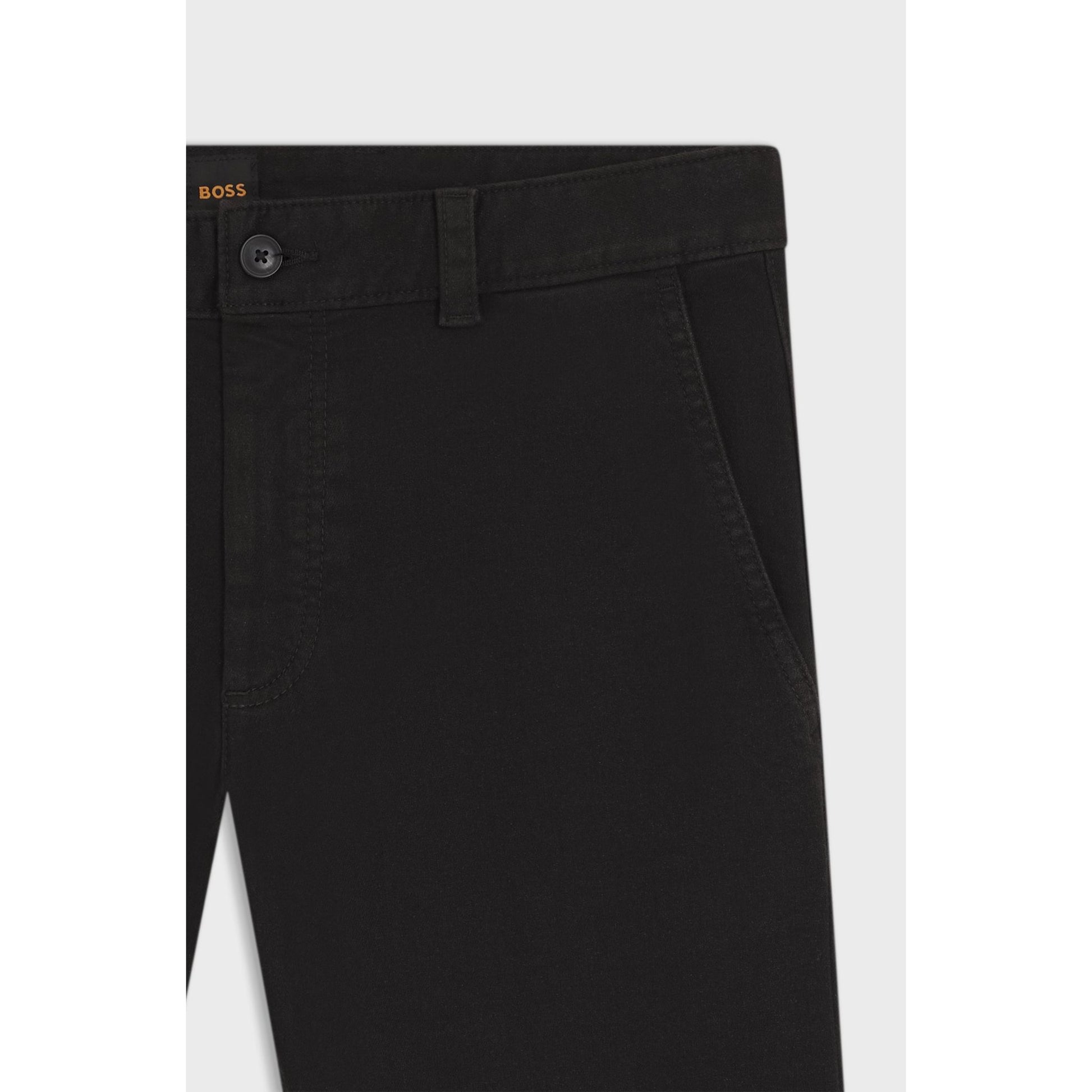 Close-up of black pants with a button and belt on a light gray background