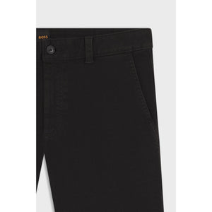 Close-up of black pants with a button and belt on a light gray background